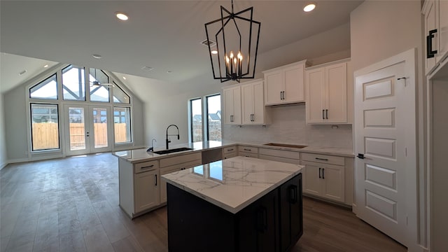 438 Silver Moon Way, Katy, TX 77493 - kitchen featuring a kitchen island, a peninsula, black electric stovetop, lofted ceiling, and dark wood-type flooring