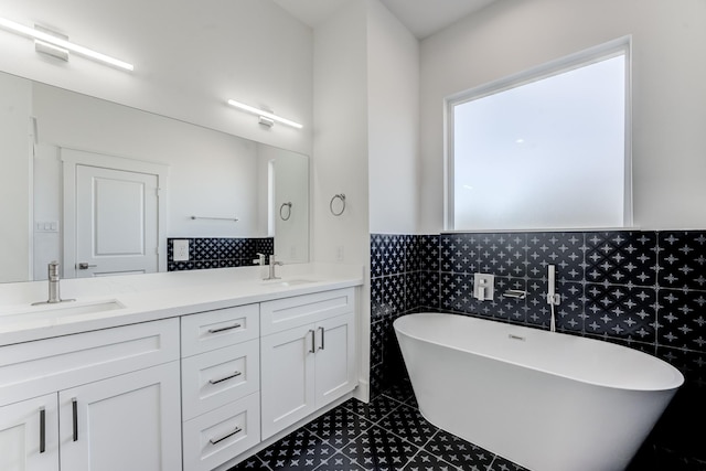 full bathroom featuring a freestanding tub, a sink, tile walls, and double vanity