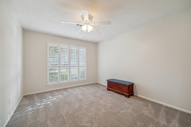 empty room featuring a ceiling fan, carpet flooring, a textured ceiling, and baseboards