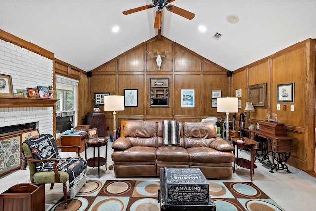 living area with vaulted ceiling with beams, visible vents, a brick fireplace, ceiling fan, and wooden walls