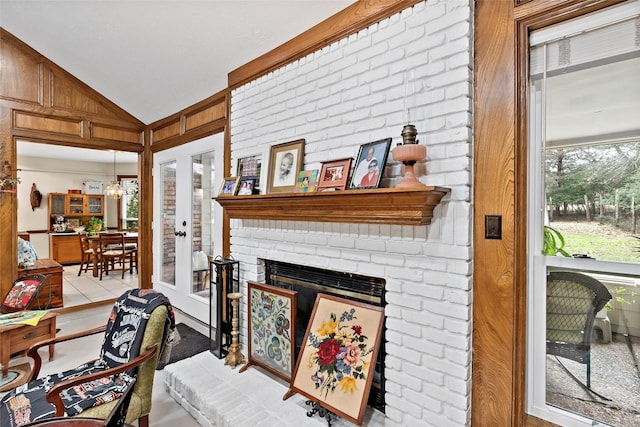 living room with vaulted ceiling and a brick fireplace