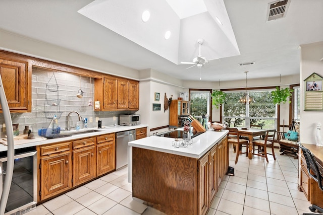 kitchen featuring wine cooler, brown cabinets, stainless steel appliances, visible vents, and a sink