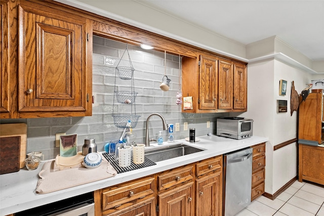 kitchen featuring brown cabinets, light tile patterned floors, light countertops, decorative backsplash, and dishwasher