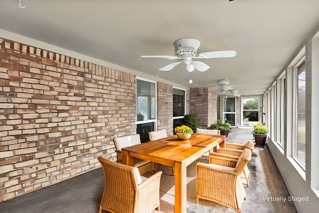 sunroom / solarium featuring a ceiling fan