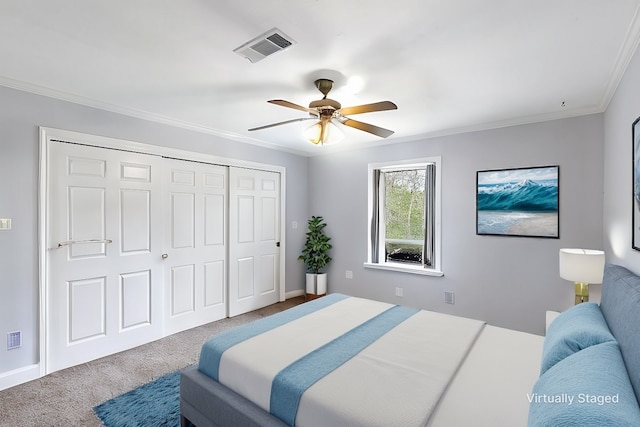 carpeted bedroom featuring a closet, visible vents, crown molding, and ceiling fan