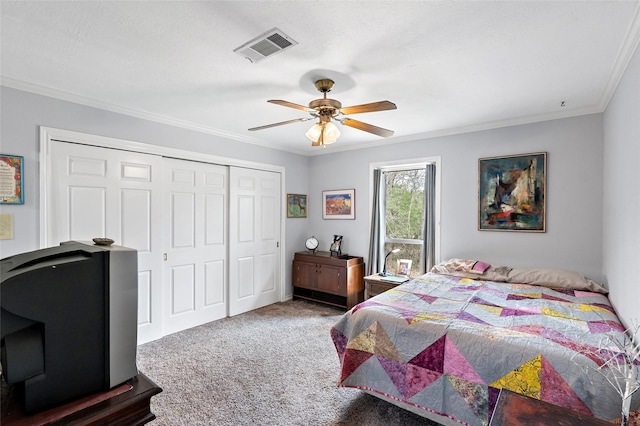 carpeted bedroom featuring a closet, visible vents, crown molding, and ceiling fan