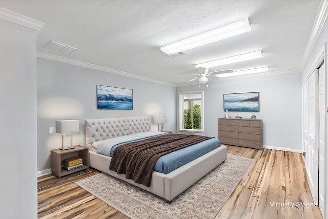 bedroom featuring ornamental molding, wood finished floors, and visible vents