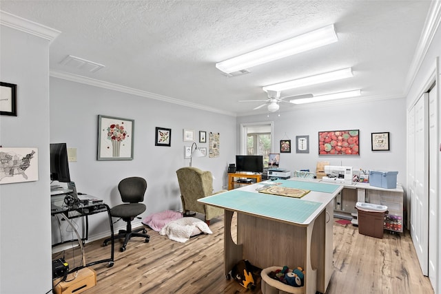 office featuring light wood-type flooring, visible vents, and crown molding