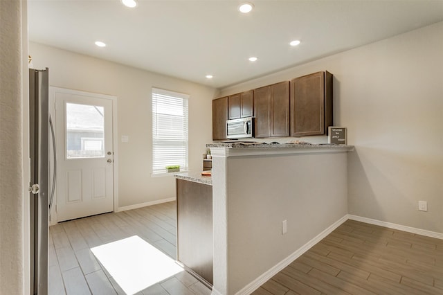 kitchen with stainless steel appliances, recessed lighting, baseboards, and light wood finished floors