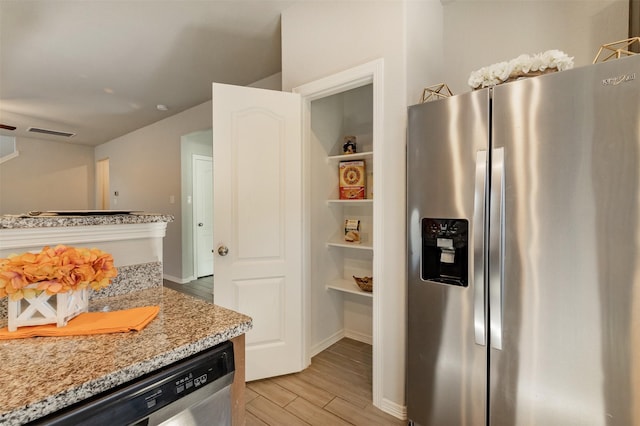 kitchen with light wood-style floors, visible vents, appliances with stainless steel finishes, and light stone counters