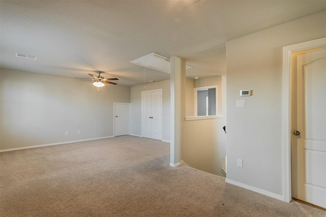 unfurnished room featuring visible vents, carpet, attic access, and baseboards