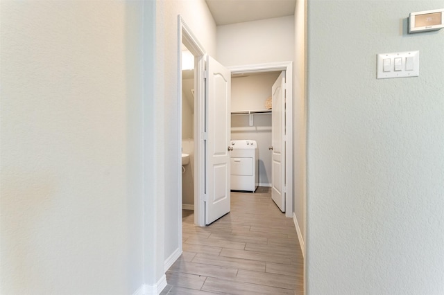 hallway with washer / clothes dryer and wood tiled floor