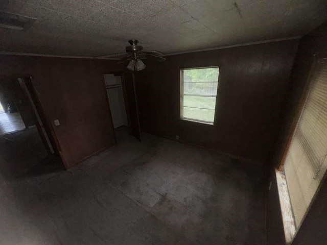 unfurnished bedroom with ceiling fan and a closet