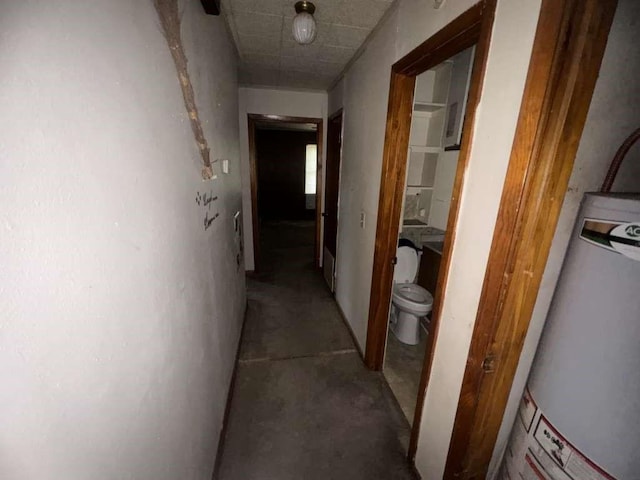 hall featuring concrete floors and water heater