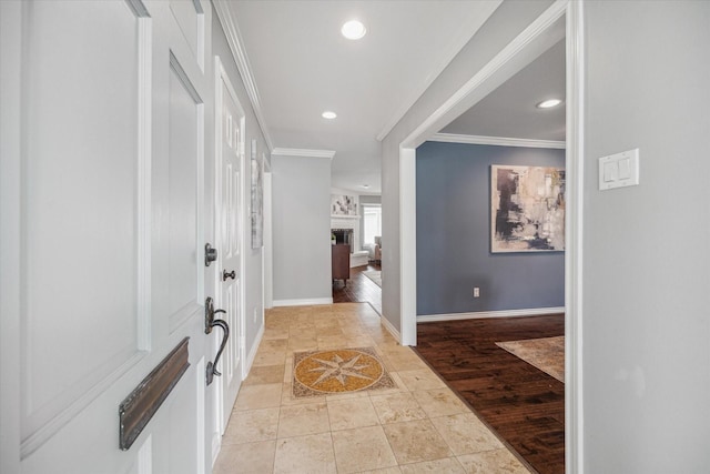 entryway with recessed lighting, a fireplace, baseboards, light wood finished floors, and crown molding