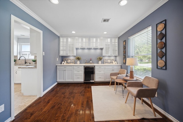 bar with baseboards, dark wood-style floors, wine cooler, ornamental molding, and a sink