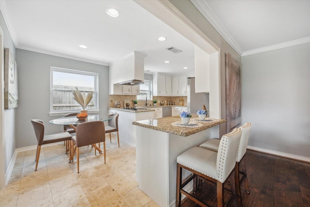 kitchen featuring tasteful backsplash, visible vents, baseboards, white cabinetry, and stainless steel dishwasher