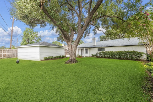 view of yard with an outbuilding and fence