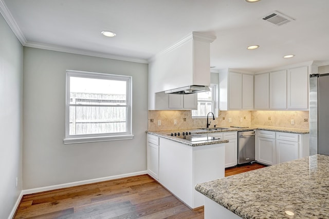 kitchen with a sink, baseboards, freestanding refrigerator, light wood finished floors, and tasteful backsplash