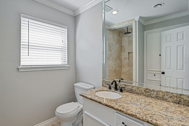 bathroom with a tile shower, toilet, and crown molding