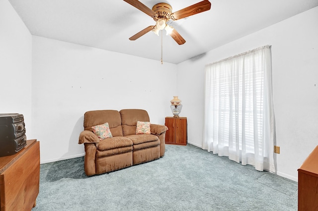 carpeted living area featuring ceiling fan and baseboards