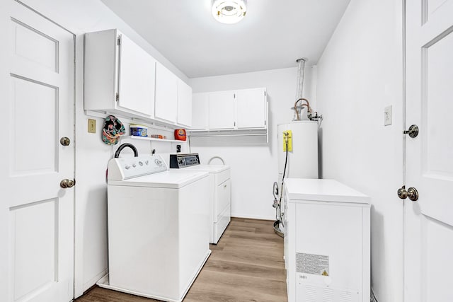 laundry room with cabinet space, baseboards, light wood-style flooring, washer and dryer, and gas water heater