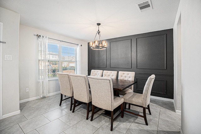 dining space featuring baseboards, light tile patterned flooring, visible vents, and an inviting chandelier