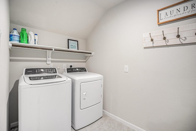 laundry area with baseboards, laundry area, light tile patterned floors, and washer and dryer