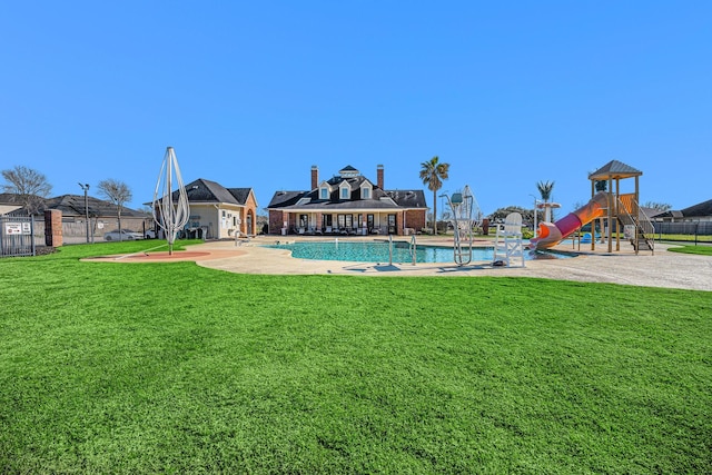 exterior space with a lawn, fence, and a community pool