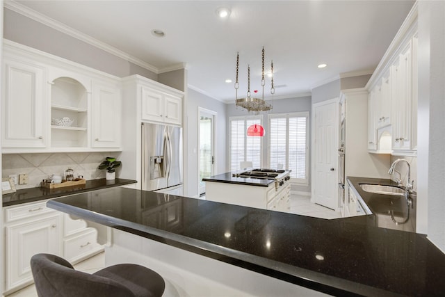 kitchen featuring dark countertops, appliances with stainless steel finishes, a sink, and a center island