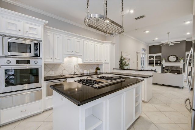 kitchen featuring a kitchen island, appliances with stainless steel finishes, a warming drawer, open shelves, and crown molding