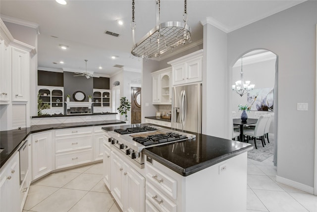 kitchen with light tile patterned floors, appliances with stainless steel finishes, crown molding, and ceiling fan with notable chandelier