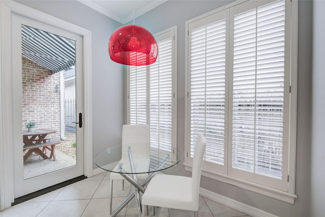 dining space with a healthy amount of sunlight, baseboards, crown molding, and tile patterned floors