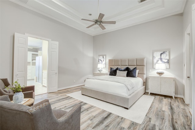 bedroom featuring wood finished floors, a raised ceiling, and crown molding