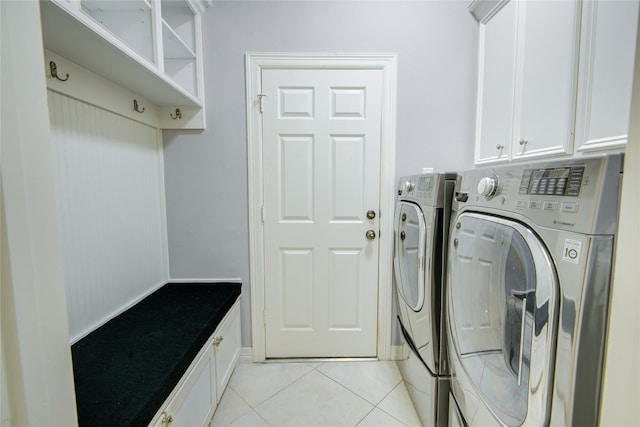 laundry room featuring cabinet space, washer and clothes dryer, and light tile patterned floors