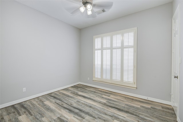 empty room featuring visible vents, ceiling fan, baseboards, and wood finished floors