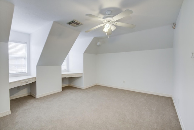 additional living space featuring plenty of natural light, visible vents, built in desk, and light colored carpet