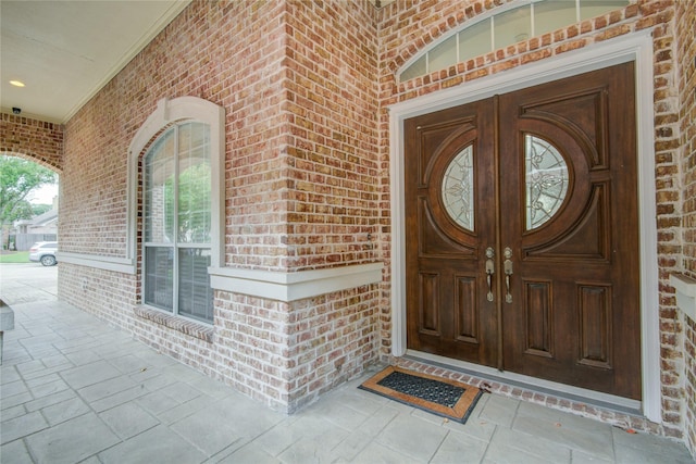 doorway to property featuring brick siding