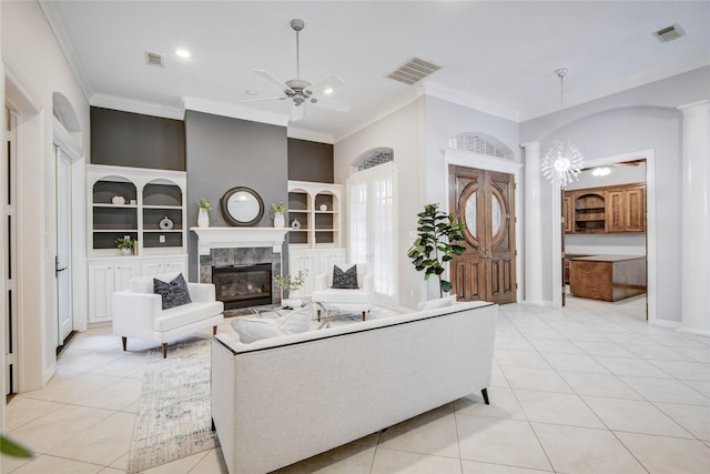 living room with light tile patterned floors, built in shelves, visible vents, and ceiling fan with notable chandelier