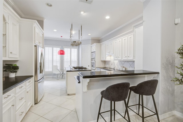 kitchen featuring stainless steel appliances, a sink, backsplash, dark countertops, and crown molding