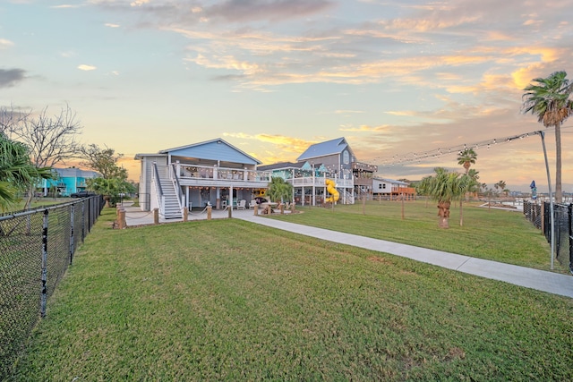 exterior space featuring a fenced backyard, stairs, a deck, and a lawn