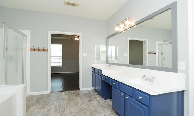 full bathroom featuring visible vents, a shower stall, wood finished floors, and a sink