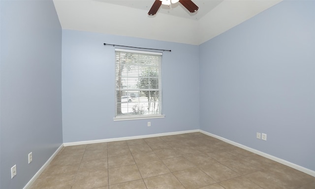 tiled empty room featuring baseboards and ceiling fan