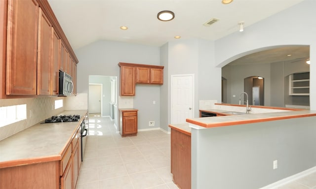 kitchen with brown cabinetry, visible vents, a sink, light countertops, and appliances with stainless steel finishes