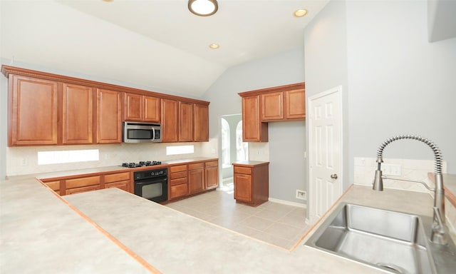 kitchen featuring black appliances, a sink, brown cabinetry, light tile patterned floors, and vaulted ceiling