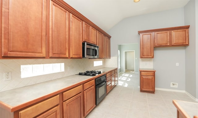 kitchen with black appliances, brown cabinetry, light tile patterned floors, decorative backsplash, and vaulted ceiling