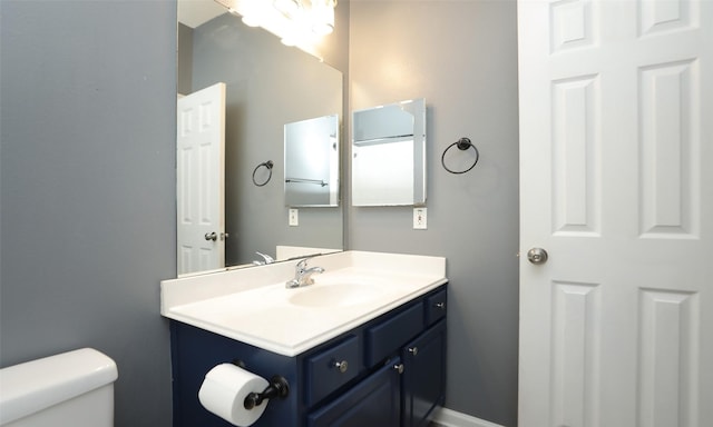 half bathroom featuring vanity and toilet