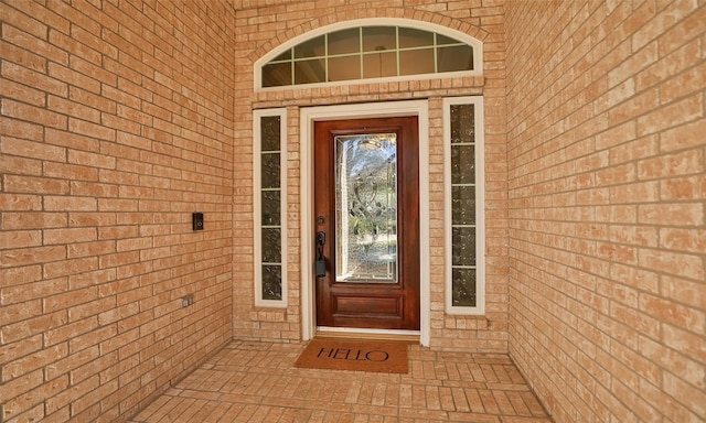 view of exterior entry featuring brick siding