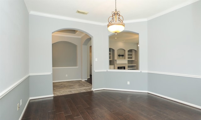 unfurnished room featuring baseboards, wood finished floors, visible vents, and ornamental molding