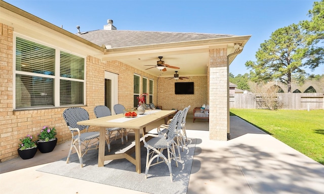 view of patio with outdoor dining area, a ceiling fan, and fence